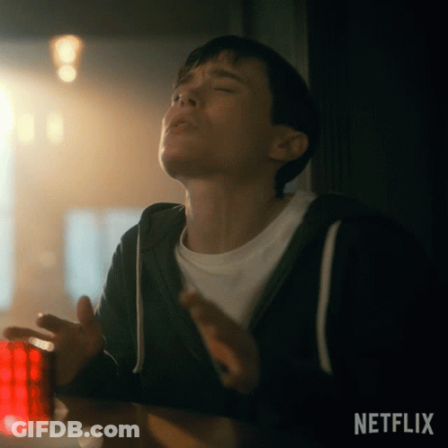 A Young Man Is Sitting At A Table With His Eyes Closed And A Netflix Logo In The Corner . GIF
