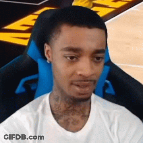 A Young Man Is Sitting In A Blue Chair On A Basketball Court . GIF