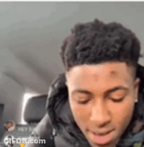 A Young Man Is Sitting In A Car With His Eyes Closed And His Mouth Open . GIF