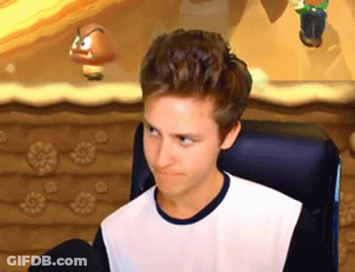 A Young Man Is Sitting In A Chair In Front Of A Video Game Screen And Making A Funny Face . GIF