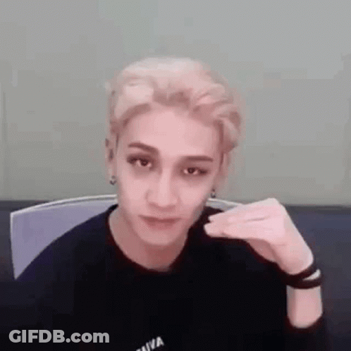 A Young Man Is Sitting In A Chair Making A Funny Face . GIF