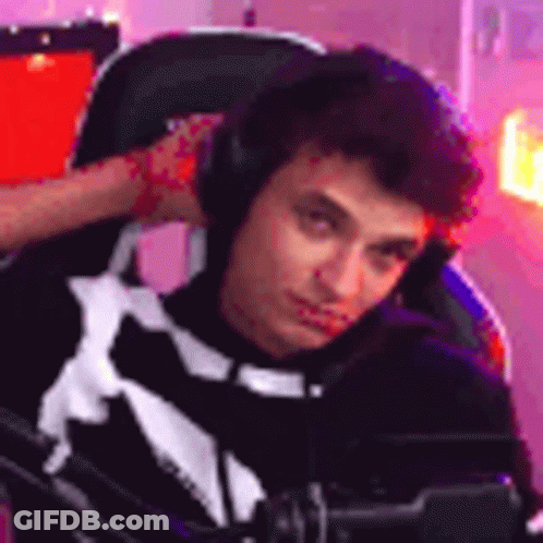 A Young Man Is Sitting In A Chair Wearing Headphones And Looking At The Camera . GIF
