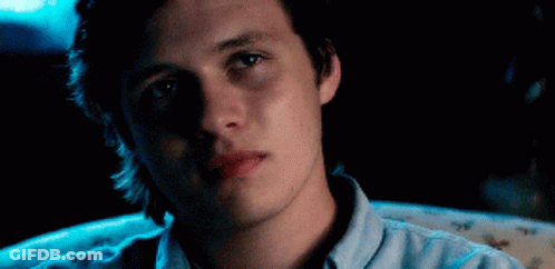 A Young Man Is Sitting In A Chair With His Eyes Closed And His Mouth Open . GIF