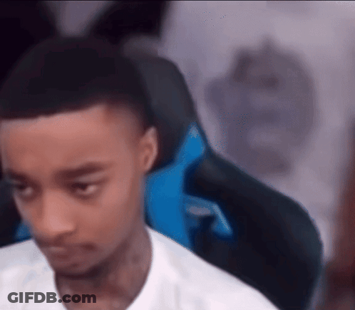 A Young Man Is Sitting In A Gaming Chair Looking At The Camera . GIF