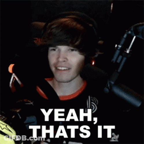A Young Man Is Sitting In Front Of A Microphone And Smiling . GIF
