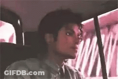 A Young Man Is Sitting In The Back Seat Of A Car . GIF