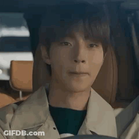 A Young Man Is Sitting In The Driver 'S Seat Of A Car And Making A Face . GIF