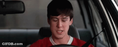 A Young Man Is Sitting In The Driver 'S Seat Of A Car With His Eyes Closed . GIF