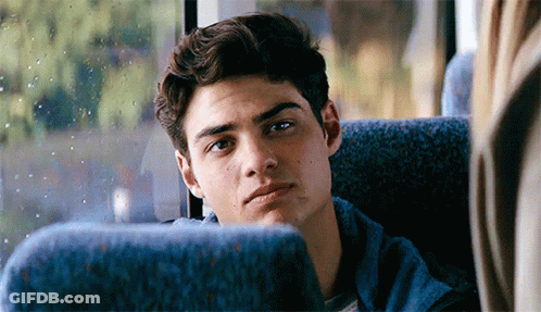 A Young Man Is Sitting On A Bus Looking Out The Window . GIF