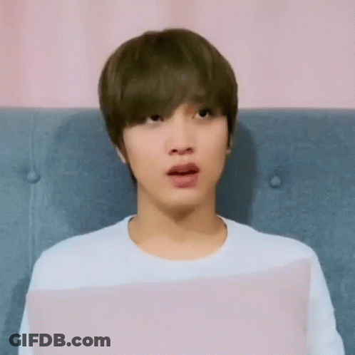 A Young Man Is Sitting On A Couch With His Mouth Open . GIF