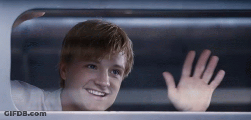 A Young Man Is Smiling And Waving His Hand GIF