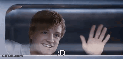A Young Man Is Smiling And Waving His Hand While Looking Out Of A Window . GIF