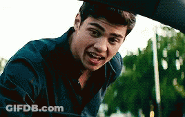 A Young Man Is Standing Next To A Car Looking Out The Window . GIF