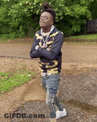 A Young Man Is Standing On A Dirt Road With His Arms Crossed And His Eyes Closed . GIF