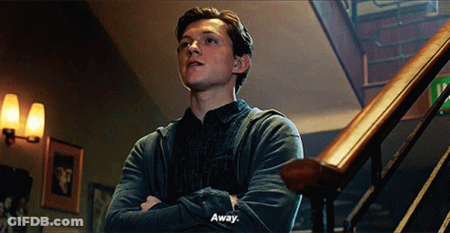 A Young Man Is Standing On A Set Of Stairs With His Arms Crossed And Saying `` Away '' . GIF
