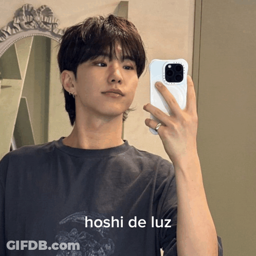 A Young Man Is Taking A Picture Of Himself In A Mirror With The Name Hoshi De Luz Written Below Him GIF
