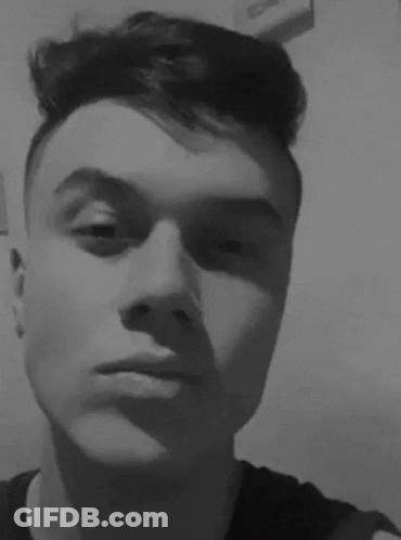 A Young Man Is Taking A Selfie In A Black And White Photo With His Eyes Closed . GIF