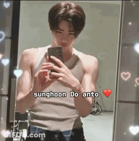A Young Man Is Taking A Selfie In Front Of A Mirror While Wearing A Tank Top . GIF