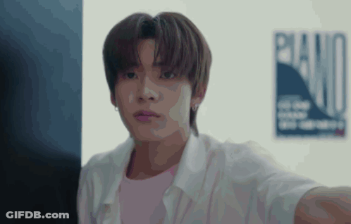 A Young Man Is Taking A Selfie In Front Of A Poster That Says Piano . GIF