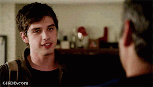 A Young Man Is Talking To Another Man In A Room GIF