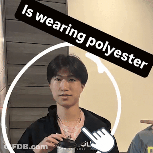 A Young Man Is Wearing A Black Jacket And Holding A Cup Of Coffee Under A Banner That Says " Is Wearing Polyester " GIF