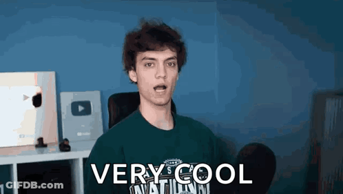 A Young Man Is Wearing A Green Shirt That Says `` Very Cool '' On It . GIF