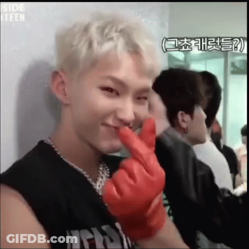 A Young Man Is Wearing A Red Glove And Making A Heart Shape With His Fingers . GIF