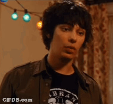 A Young Man Is Wearing A Shirt That Says Brat On It GIF
