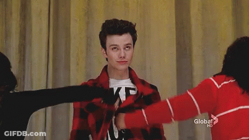 A Young Man Is Wearing A T-Shirt That Says `` Likes Boys '' And A Red Plaid Jacket . GIF