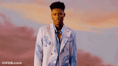 A Young Man Is Wearing A White Jacket And A Blue Shirt . GIF
