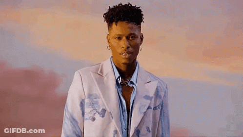 A Young Man Is Wearing A White Jacket And A Blue Shirt . GIF