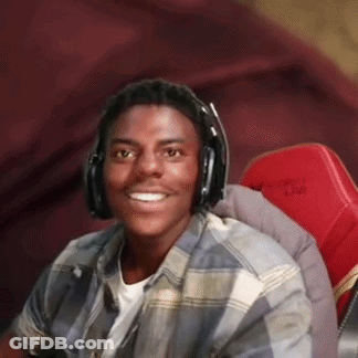A Young Man Is Wearing Headphones And Smiling While Sitting In A Red Chair . GIF