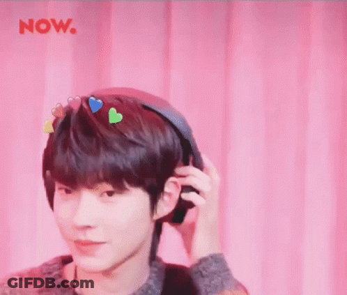 A Young Man Is Wearing Headphones With Hearts On His Head . GIF