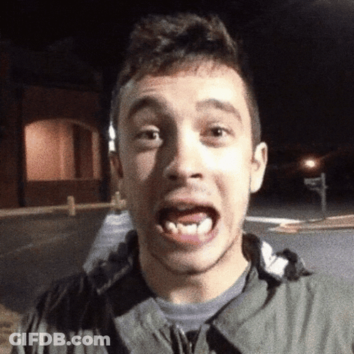 A Young Man Making A Funny Face While Wearing A Grey Jacket GIF