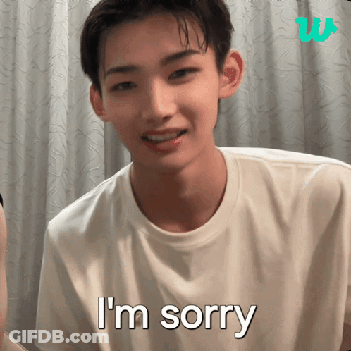 A Young Man Says I 'M Sorry In Front Of A White Curtain GIF