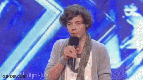 A Young Man Singing Into A Microphone On A Stage With The Words Auditions ( April July ) Written On The Bottom GIF