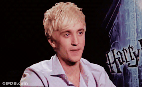 A Young Man Sitting In Front Of A Harry Potter Sign GIF
