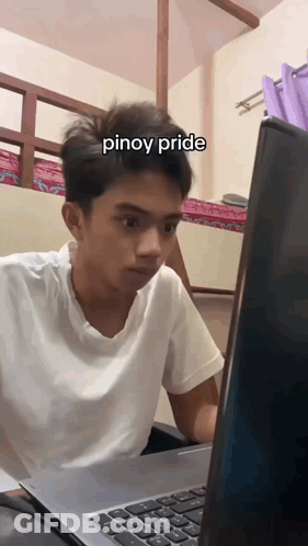 A Young Man Sitting In Front Of A Laptop With The Word Pinoy Pride Written On His Face GIF