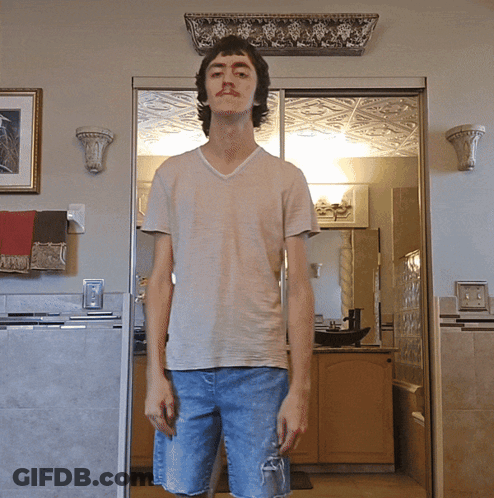 A Young Man Standing In Front Of A Sliding Glass Door In A Kitchen GIF