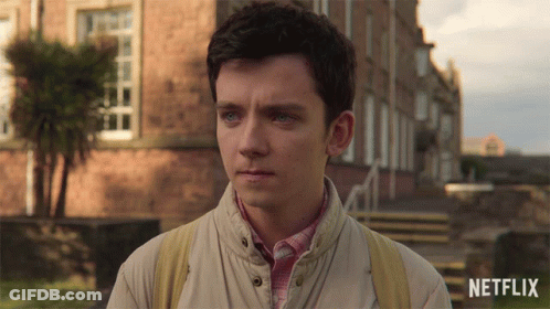 A Young Man Stands In Front Of A Building With A Netflix Logo On The Bottom Right GIF