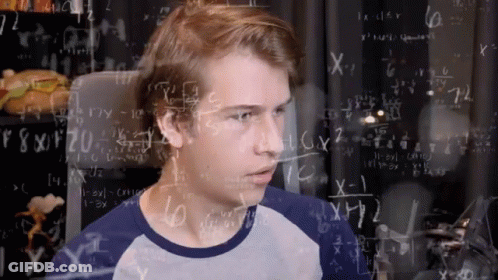 A Young Man Stands In Front Of A Chalkboard Filled With Math Equations GIF