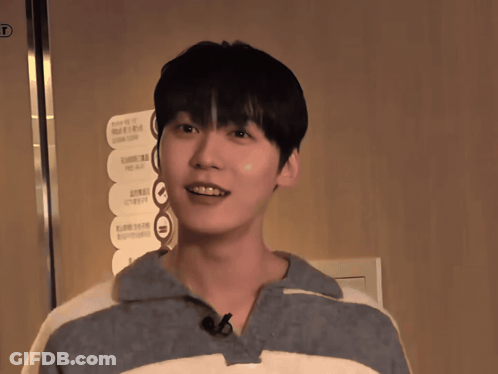 A Young Man Stands In Front Of A Sign That Says ' Elevator ' On It GIF