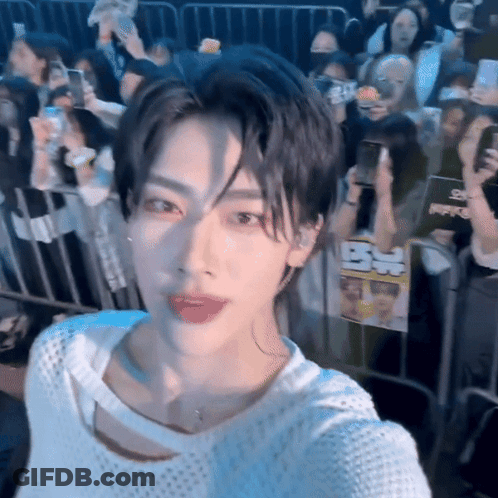 A Young Man Taking A Selfie In Front Of A Crowd Of People GIF