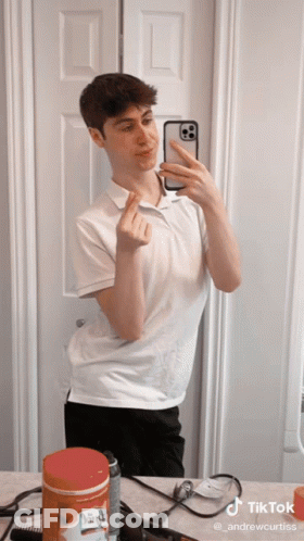 A Young Man Taking A Selfie In Front Of A Mirror With A Tiktok Watermark On The Bottom GIF