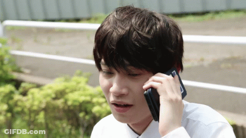 A Young Man Talking On A Cell Phone With A Surprised Look On His Face GIF