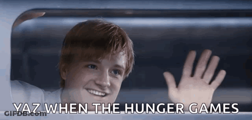 A Young Man Waving Out Of A Window With Yaz When The Hunger Games Below Him GIF