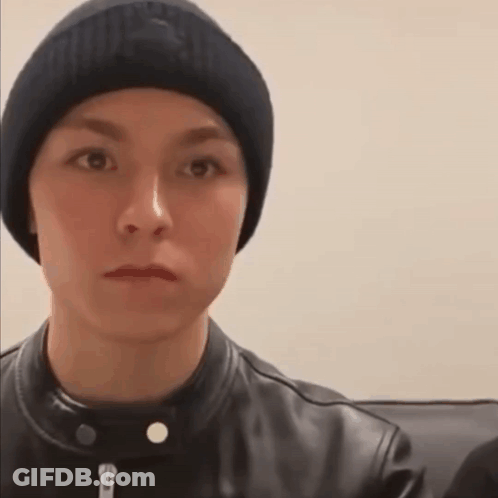A Young Man Wearing A Beanie And A Leather Jacket Is Making A Funny Face . GIF
