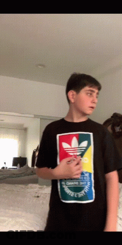 A Young Man Wearing A Black Adidas Shirt GIF