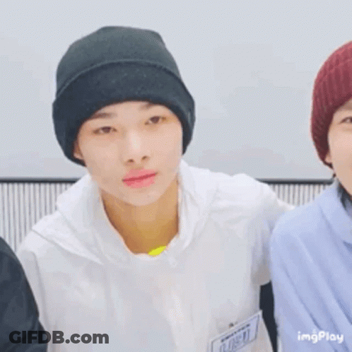 A Young Man Wearing A Black Beanie Is Smiling While Standing Next To Another Young Man . GIF