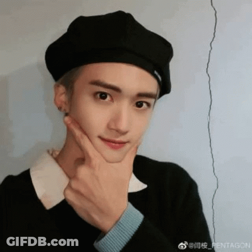 A Young Man Wearing A Black Beret Is Making A Funny Face With His Hand On His Chin . GIF